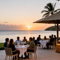 Caribbean Holidays, Grenada Business Class, A stylish beachfront resort in Grenada at sunset, with guests dining outdoors beside a calm sea