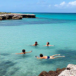 Caribbean Holidays, Grenada January Holidays, Travellers swimming and snorkelling in clear Caribbean water near Grenada, with colourful fish, rocky coastline and bright January sunshine