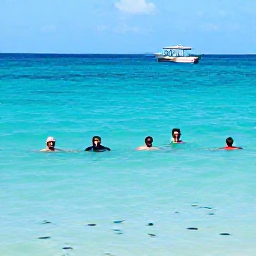 Caribbean Holidays, Grenada January Holidays, Visitors swimming and snorkelling in clear Caribbean water near a Grenada beach, with colourful fish and a small boat offshore