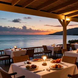Caribbean Holidays, Grenada Luxury Holidays, Elegant Grenada restaurant terrace overlooking the sea at sunset, with local seafood dishes and softly lit tables