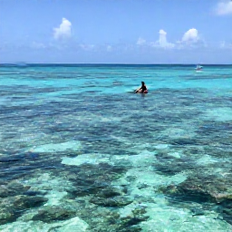 Caribbean Holidays, Guadeloupe Beach Holidays, Travellers snorkelling above a shallow coral reef in clear Caribbean water near Guadeloupe, with tropical fish and a small sailing boat in the distance