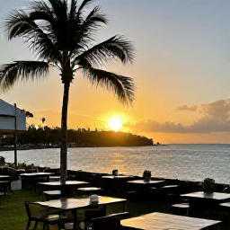 Caribbean Holidays, Guadeloupe December Break, Relaxed outdoor caf&eacute; beside the waterfront in Guadeloupe at sunset, with warm light, palm trees and Caribbean scenery