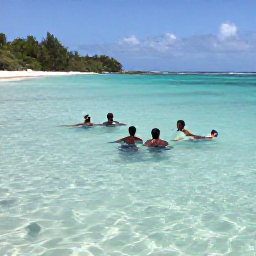 Caribbean Holidays, Guadeloupe in June, Travellers swimming and snorkelling in clear shallow water beside a tropical Guadeloupe beach, with colourful fish visible below the surface