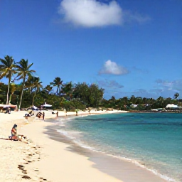 Caribbean Holidays, Guadeloupe October Break, Golden Guadeloupe beach near Le Gosier with clear turquoise water, palm trees and visitors relaxing in October sunshine