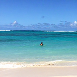 Caribbean Holidays, Guadeloupe Solo Holidays, A solo traveller swimming in clear turquoise water beside a quiet sandy beach on Guadeloupe&rsquo;s Grande-Terre coast