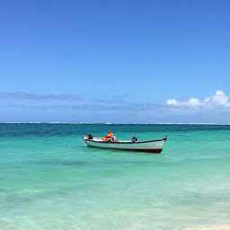 Caribbean Holidays, Haiti Backpacking, Palm-fringed Labadee coastline in Haiti with clear turquoise water, a small fishing boat and travellers relaxing on a sunny February day