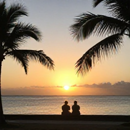 Caribbean Holidays, Jamaica April Holidays, A couple watching the sun set over the sea from Negril, Jamaica, with warm evening light and palm silhouettes