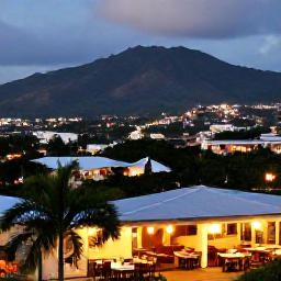 Caribbean Holidays, Jamaica August Breaks, Evening view over Kingston with warm city lights, restaurants and distant Blue Mountains, realistic travel photograph