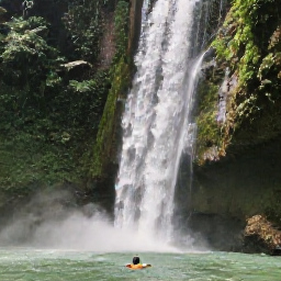 Caribbean Holidays, Jamaica Backpacking December, Jamaican backpacker swimming beneath a tropical waterfall surrounded by green forest
