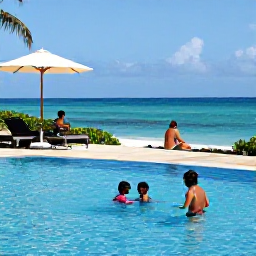 Caribbean Holidays, Jamaica Family Holidays, Family relaxing beside a resort pool overlooking the Jamaican coast, children swimming and parents enjoying the sunshine