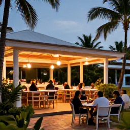 Caribbean Holidays, Jamaica in August, A relaxed Jamaican beach resort in August, open-air restaurant, tropical gardens, palm trees and guests enjoying the evening
