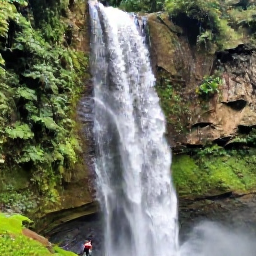 Caribbean Holidays, Jamaica Nature Holidays, Dunn's River Falls in Jamaica with visitors climbing the broad natural limestone cascade surrounded by green vegetation
