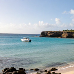 Caribbean Holidays, January Adventures, A sunny January morning on Cura&ccedil;ao with turquoise Caribbean water, rugged coastline and a small adventure boat near shore
