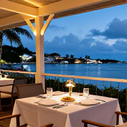Caribbean Holidays, January Beach Holidays, Outdoor table at a stylish Gustavia restaurant in the evening, with Caribbean dishes, soft lights and harbour views