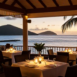 Caribbean Holidays, January Escapes, Outdoor Caribbean restaurant with tables set for dinner, warm sunset light and a view across the British Virgin Islands sea
