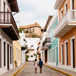 Caribbean Holidays, January Honeymoons, Couple exploring colourful cobbled street in Old San Juan, colonial buildings, balconies and historic fort in the background