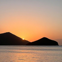 Caribbean Holidays, January Instagram Hotspots, Sunset over Frigate Bay, Saint Kitts, with calm sea, dark volcanic hills and warm orange light across the horizon