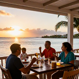 Caribbean Holidays, June Family Holidays, Family eating a relaxed seaside dinner at a casual restaurant in Providenciales, Turks and Caicos, at sunset