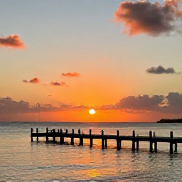 Caribbean Holidays, June Instagram Hotspots, Sunset at Frederiksted Pier on St Croix, with calm Caribbean water, a wooden pier and a colourful orange and pink sky