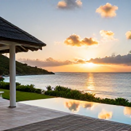 Caribbean Holidays, Luxury February, Luxury beachfront villa terrace overlooking a calm Caribbean sea at sunset in Saint Barth&eacute;lemy