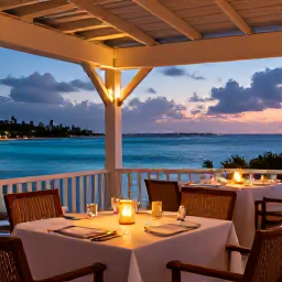 Caribbean Holidays, Luxury Holidays, Romantic beachfront restaurant in Cura&ccedil;ao at dusk, with elegant tables, candles and views across the Caribbean Sea