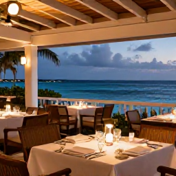 Caribbean Holidays, Luxury Turks Caicos, Elegant open-air restaurant overlooking the sea in Providenciales, Turks and Caicos, beautifully presented Caribbean dinner at dusk