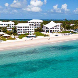 Caribbean Holidays, March All Inclusive, A bright aerial view of Grace Bay Beach in the Turks and Caicos Islands, with clear turquoise water, soft white sand and a relaxed all-inclusive resort atmosphere