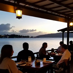Caribbean Holidays, Martinique Solo Holidays, A relaxed solo diner enjoying Creole food at a waterside restaurant in Martinique at sunset, with lanterns and a view of the bay