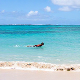 Caribbean Holidays, Martinique Solo Holidays, A solo traveller swimming in clear turquoise water beside a sandy beach in Martinique during September