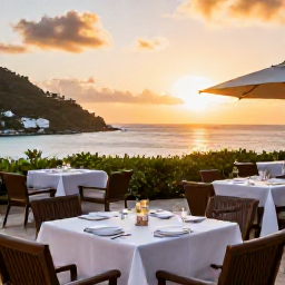 Caribbean Holidays, May Luxury Holidays, Elegant luxury hotel terrace overlooking a tropical bay in Saint Vincent and the Grenadines, with outdoor dining and sunset views