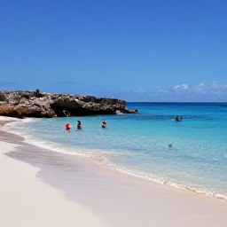 Caribbean Holidays, October Cura&ccedil;ao, A secluded Cura&ccedil;ao beach with clear blue water, pale sand, rocky coastline and snorkellers exploring the calm sea in October sunshine