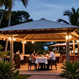 Caribbean Holidays, October Escapes, Outdoor Caribbean restaurant in Tobago at dusk, with couples dining beneath soft lights and tropical vegetation around the terrace