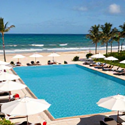 Caribbean Holidays, Puerto Rico May, Elegant all-inclusive resort pool beside a sandy Puerto Rican beach, guests relaxing under umbrellas