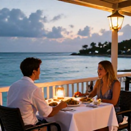 Caribbean Holidays, Romantic Caribbean, Romantic Caribbean restaurant terrace overlooking the sea at dusk, couple dining at a table with local food and soft lantern light