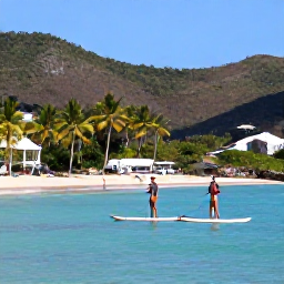 Caribbean Holidays, Saint Barth Adventure, Visitors paddleboarding on calm turquoise water near a sandy beach in Saint Barth&eacute;lemy, with palm trees and hills behind