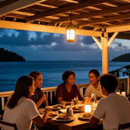 Caribbean Holidays, Saint Lucia Holidays, A relaxed evening in Saint Lucia with diners enjoying local food at an open-air restaurant, warm lantern light and a view towards the sea