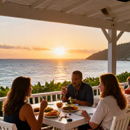 Caribbean Holidays, Saint Vincent All Inclusive, Guests enjoying an open-air resort restaurant overlooking the Caribbean Sea at sunset, with fresh local food and relaxed island dining