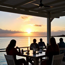 Caribbean Holidays, September Adventures, Relaxed outdoor beach restaurant at sunset with diners overlooking the calm sea in Turks and Caicos