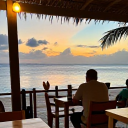 Caribbean Holidays, September Solo Holidays, A relaxed evening scene at a beach restaurant in Aruba, with a solo diner watching the sunset over the Caribbean Sea