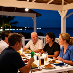 Caribbean Holidays, Turks and Caicos November, Friendly visitors dining outdoors at a locally inspired restaurant in Turks and Caicos, with seafood dishes and a relaxed island evening atmosphere