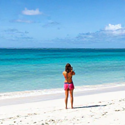 Caribbean Holidays, Turks Caicos Instagram, Bright turquoise water, white sand beach and a relaxed traveller taking a photograph at Grace Bay, Turks and Caicos, in warm March sunshine