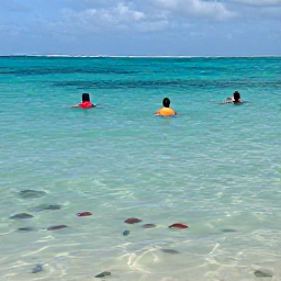 Caribbean Holidays, Turks Caicos May, Visitors swimming and relaxing in the shallow clear waters of Grace Bay, Turks and Caicos, with colourful fish visible beneath the surface