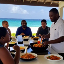 Caribbean Holidays, Virgin Islands Cooking, Chef teaching visitors to prepare Caribbean seafood and traditional side dishes in an open-air kitchen overlooking the sea