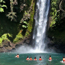 Caribbean Holidays, Waterfall Tours, Visitors swimming in a clear natural pool beneath a Caribbean waterfall in bright tropical surroundings